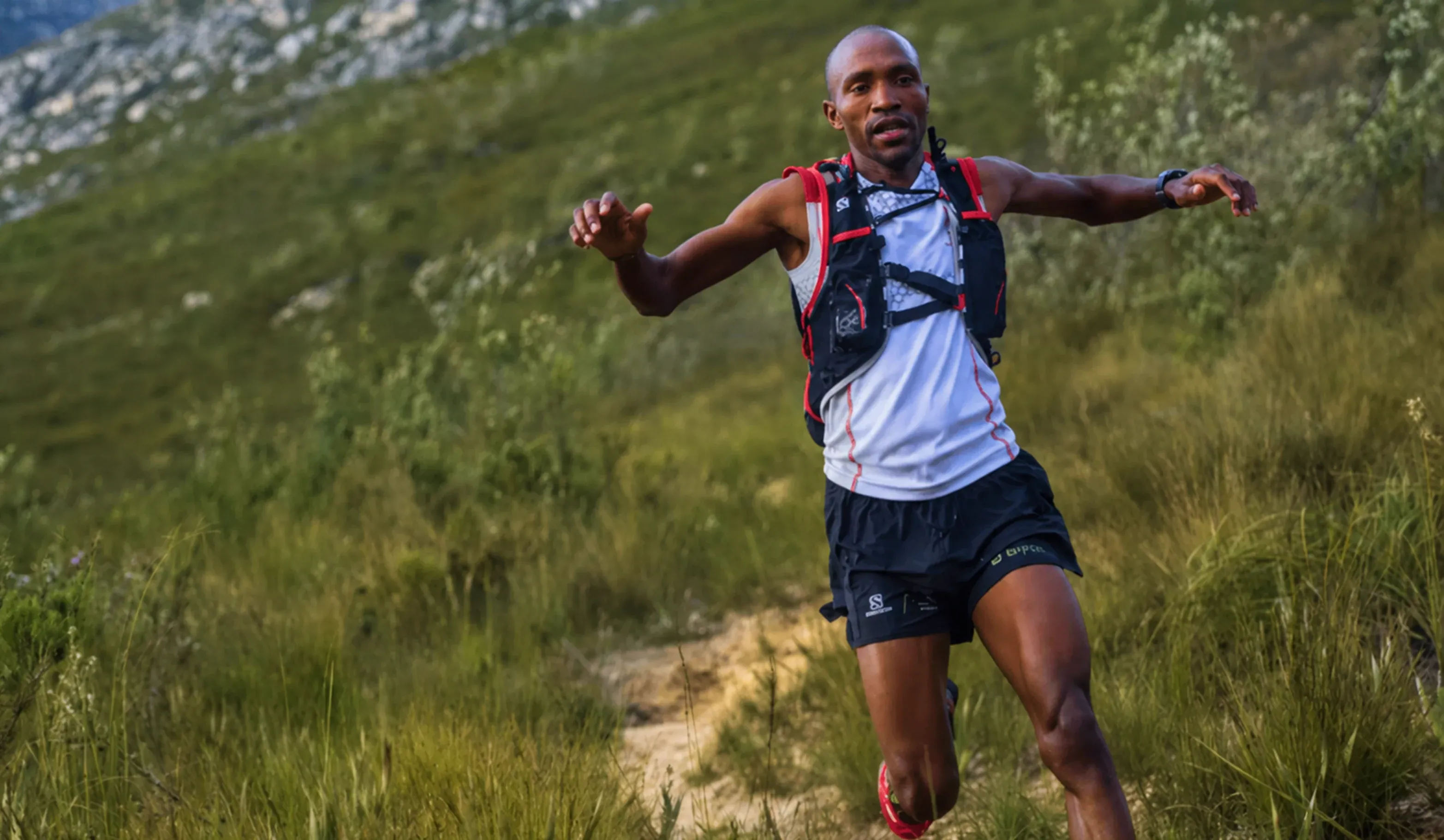 Trail runner descending a technical mountain trail with controlled posture